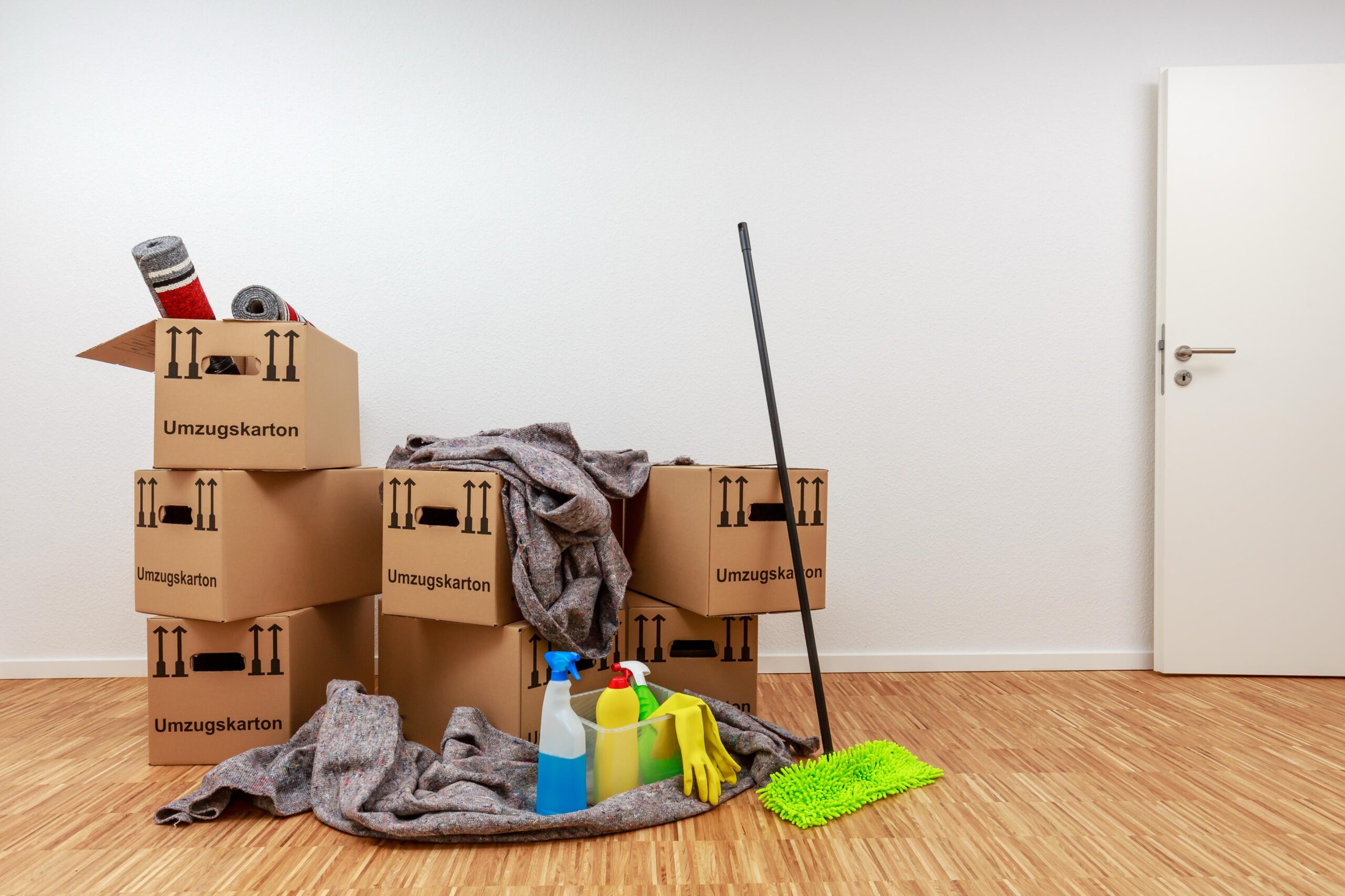 Umzugskartons und Reinigungsutensilien stehen für eine strukturierte Firmenauflösung in Hagen mit geordneter Räumung von Geschäftsflächen.